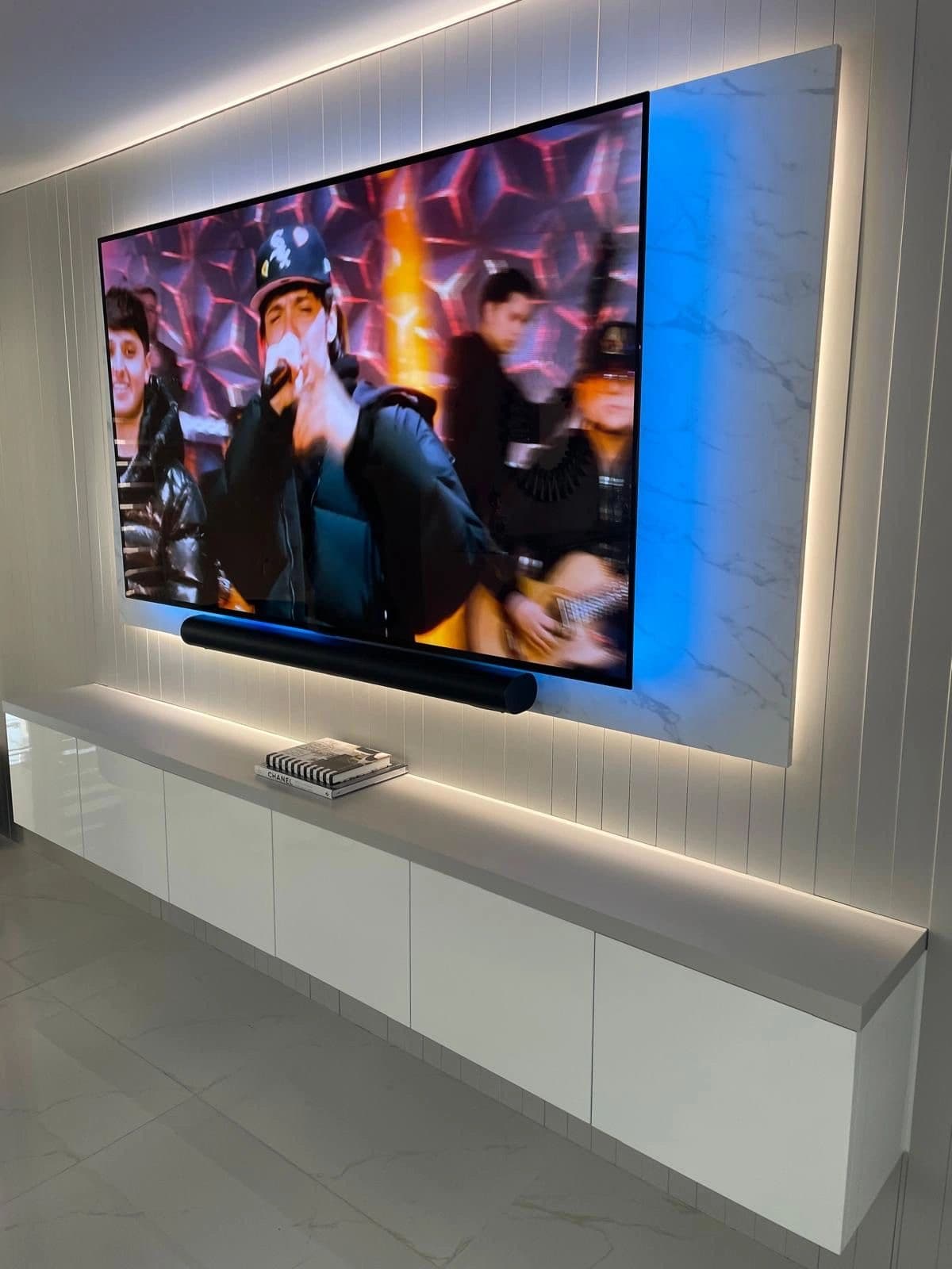 Wall-mounted TV with LED backlight over a floating white console